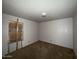 Small bedroom featuring neutral walls, a dark carpet, and a window covered in plywood at 12231 N 22Nd Ave, Phoenix, AZ 85029