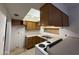 Compact kitchen with dated appliances, wood cabinets, and a window boarded up with plywood at 12231 N 22Nd Ave, Phoenix, AZ 85029