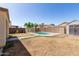 Fenced backyard with patch lawn, pool area, shed, and views of neighboring houses at 12430 W Scotts Dr, El Mirage, AZ 85335