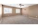 Bedroom featuring neutral carpet, ceiling fan, and two bright windows at 12430 W Scotts Dr, El Mirage, AZ 85335