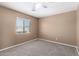 Bedroom featuring neutral carpet, a ceiling fan, and a bright window with blinds at 12430 W Scotts Dr, El Mirage, AZ 85335