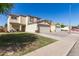 Residential street featuring a two-story home with a two-car garage and sidewalk at 12430 W Scotts Dr, El Mirage, AZ 85335