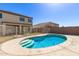 Backyard view with a pool, a secure fence, and a two-story home in the background at 12430 W Scotts Dr, El Mirage, AZ 85335