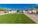 Backyard with artificial turf, rock landscaping, patio furniture, and outdoor entertainment space at 14616 N 28Th Pl, Phoenix, AZ 85032