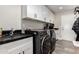 Well-equipped laundry room with modern appliances, black countertops, sink and overhead cabinets at 14616 N 28Th Pl, Phoenix, AZ 85032