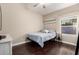 Bright bedroom featuring a comfortable bed, hardwood floors, and natural light from the large window at 16014 S 13Th Way, Phoenix, AZ 85048