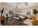 Spacious living room with dark hardwood floors, a large sectional sofa, and plenty of natural light at 16014 S 13Th Way, Phoenix, AZ 85048