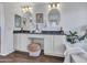 Stylish bathroom featuring a double vanity with granite countertops, oval mirrors, and a luxurious soaking tub at 16322 N 171St Dr, Surprise, AZ 85388