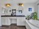 Well-lit main bathroom featuring dual sinks, large mirrors, and soaking tub at 16322 N 171St Dr, Surprise, AZ 85388