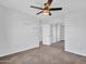 Spacious bedroom featuring carpet, a ceiling fan, and a mirrored closet for ample storage at 16322 N 171St Dr, Surprise, AZ 85388