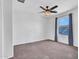 Bright bedroom with neutral carpet, a window providing natural light, and a ceiling fan for added comfort at 16322 N 171St Dr, Surprise, AZ 85388