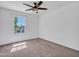Bright bedroom with neutral carpet, a window providing natural light, and a ceiling fan for added comfort at 16322 N 171St Dr, Surprise, AZ 85388