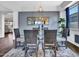 A dining room boasts wood-look floors, an elegant glass table, and a modern light fixture above the table at 16322 N 171St Dr, Surprise, AZ 85388
