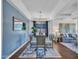 A dining room features a glass table with seating for six, alongside blue accent walls and a stylish light fixture at 16322 N 171St Dr, Surprise, AZ 85388