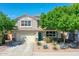 Charming two-story home with landscaped yard, desert plants, a two-car garage, and a welcoming entrance at 16322 N 171St Dr, Surprise, AZ 85388