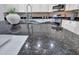 Close-up view of a dark granite kitchen countertop, showcasing stainless steel appliances and white cabinetry at 16322 N 171St Dr, Surprise, AZ 85388