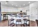 A kitchen island with barstool seating showcases granite countertops, white cabinets, and stainless steel appliances at 16322 N 171St Dr, Surprise, AZ 85388