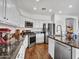 Modern kitchen featuring white cabinets, stainless steel appliances, a granite countertop, and hardwood floors at 16322 N 171St Dr, Surprise, AZ 85388