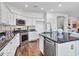 Open kitchen with stainless steel appliances, white cabinets, and hardwood flooring at 16322 N 171St Dr, Surprise, AZ 85388