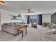 Spacious living room with a large gray sectional, plush carpet, and plenty of natural light at 16322 N 171St Dr, Surprise, AZ 85388