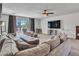 Comfortable living room featuring a large sectional, ceiling fan, TV and view of the neighborhood at 16322 N 171St Dr, Surprise, AZ 85388