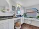 This main bathroom features double sinks, dark granite countertops, and a soaking tub with a view at 16322 N 171St Dr, Surprise, AZ 85388