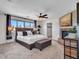 This main bedroom features a ceiling fan, fireplace, large windows and stylish decor at 16322 N 171St Dr, Surprise, AZ 85388