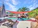 Inviting pool area featuring lush landscaping, a waterfall feature, and comfortable lounge seating at 16322 N 171St Dr, Surprise, AZ 85388