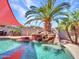 Backyard pool featuring an eye-catching rock waterfall, lush palm trees, and a stylish sunshade at 16322 N 171St Dr, Surprise, AZ 85388
