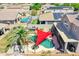 Aerial view of a private backyard pool with a unique sunshade and lush landscaping at 16322 N 171St Dr, Surprise, AZ 85388
