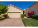 Charming home exterior featuring a two-car garage, terra cotta roof, and meticulously landscaped front yard at 1700 E Lakeside Dr # 64, Gilbert, AZ 85234