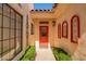 Inviting entryway with a striking red front door, decorative wall accents, and manicured greenery at 1700 E Lakeside Dr # 64, Gilbert, AZ 85234