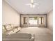 Living room featuring a large sofa, carpeted floors, ceiling fan and sliding glass doors at 1700 E Lakeside Dr # 64, Gilbert, AZ 85234