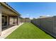 Manicured backyard featuring artificial grass, shade structures and privacy wall at 17219 W Gibson Ln, Goodyear, AZ 85338
