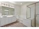Contemporary bathroom with dual sinks, a soaking tub, and a separate glass-enclosed shower at 17219 W Gibson Ln, Goodyear, AZ 85338