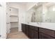 Bathroom featuring double sinks, walk-in closet and large mirror at 17279 W Dartmouth St, Surprise, AZ 85388