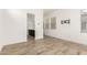 Spacious bedroom leading to bathroom, featuring wood-style tile flooring at 17279 W Dartmouth St, Surprise, AZ 85388