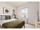Staged bedroom featuring a queen-sized bed and wood-style tile flooring at 17279 W Dartmouth St, Surprise, AZ 85388