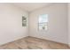 Empty bedroom with multiple windows and wood-style tile flooring at 17279 W Dartmouth St, Surprise, AZ 85388
