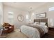 Bright bedroom with a neutral palette and plush carpeting, featuring a cozy seating area at 17279 W Dartmouth St, Surprise, AZ 85388