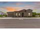 Stunning exterior with warm tones, red tile roof, desert landscaping, and a sunset sky backdrop at 17279 W Dartmouth St, Surprise, AZ 85388