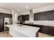 Open kitchen with a large island, modern appliances, and sleek, dark brown cabinets at 17279 W Dartmouth St, Surprise, AZ 85388