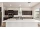 Kitchen with quartz countertops, stainless steel appliances, dark wood cabinets, and range hood at 17279 W Dartmouth St, Surprise, AZ 85388
