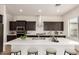 Kitchen with quartz countertops, stainless steel appliances, dark wood cabinets, and range hood at 17279 W Dartmouth St, Surprise, AZ 85388