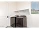 Laundry room showcases side-by-side washer and dryer, with a window and overhead shelf at 17279 W Dartmouth St, Surprise, AZ 85388