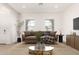 Bright living room with modern furniture, patterned rug, and large windows with blinds at 17279 W Dartmouth St, Surprise, AZ 85388