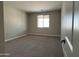 Cozy bedroom with neutral tones, carpet flooring, a window allowing natural light, and a serene ambiance at 17482 W Fulton St, Goodyear, AZ 85338