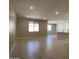 Open-concept living room with tile flooring, recessed lighting, and abundant natural light from large windows at 17482 W Fulton St, Goodyear, AZ 85338