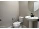 Stylish powder room featuring a pedestal sink with black fixtures and modern accents for guests' convenience at 17482 W Fulton St, Goodyear, AZ 85338