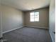 Cozy bedroom featuring neutral walls, plush carpeting, and a bright window at 17488 W Fulton St, Goodyear, AZ 85338